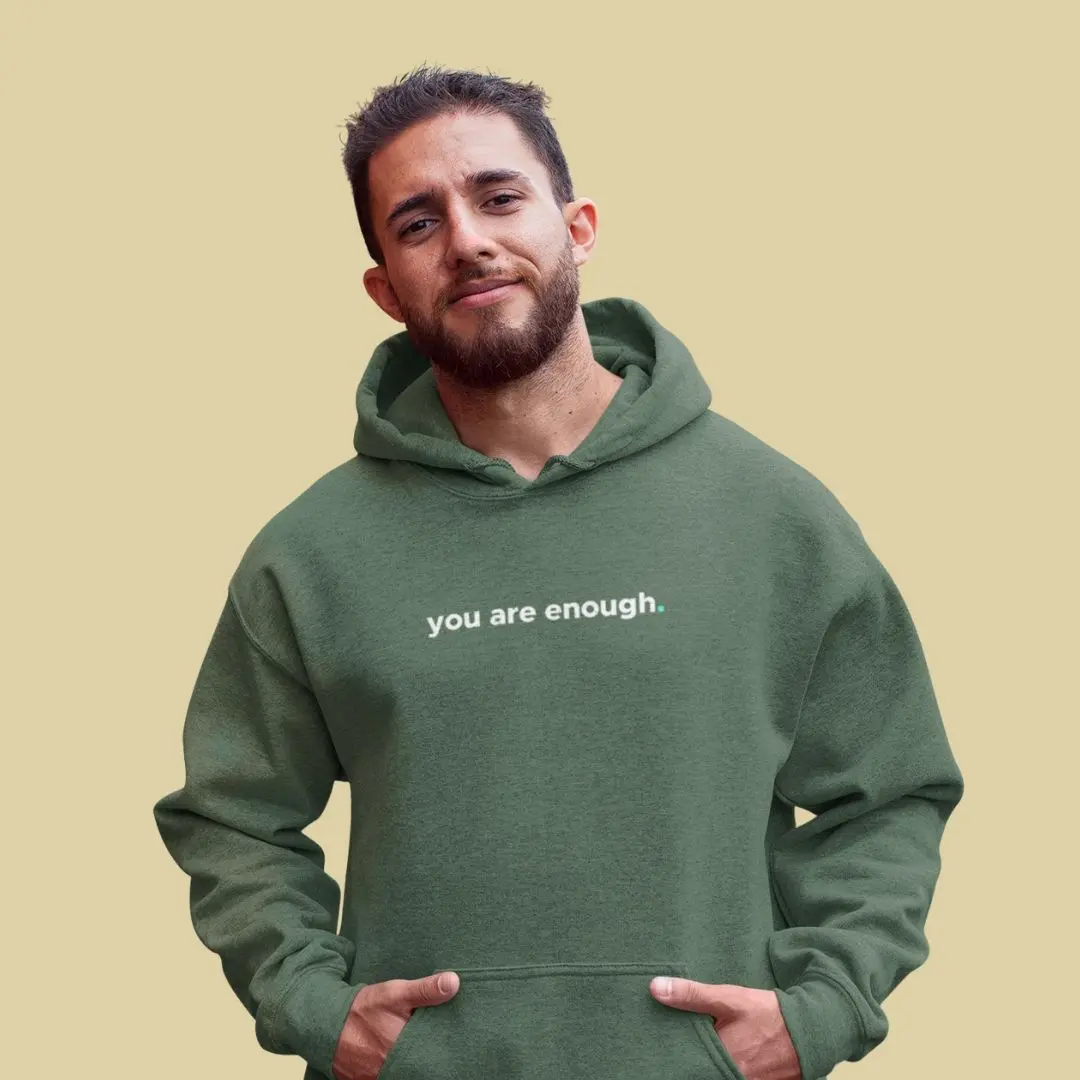 Person wearing 'you are enough' green hoodie.
