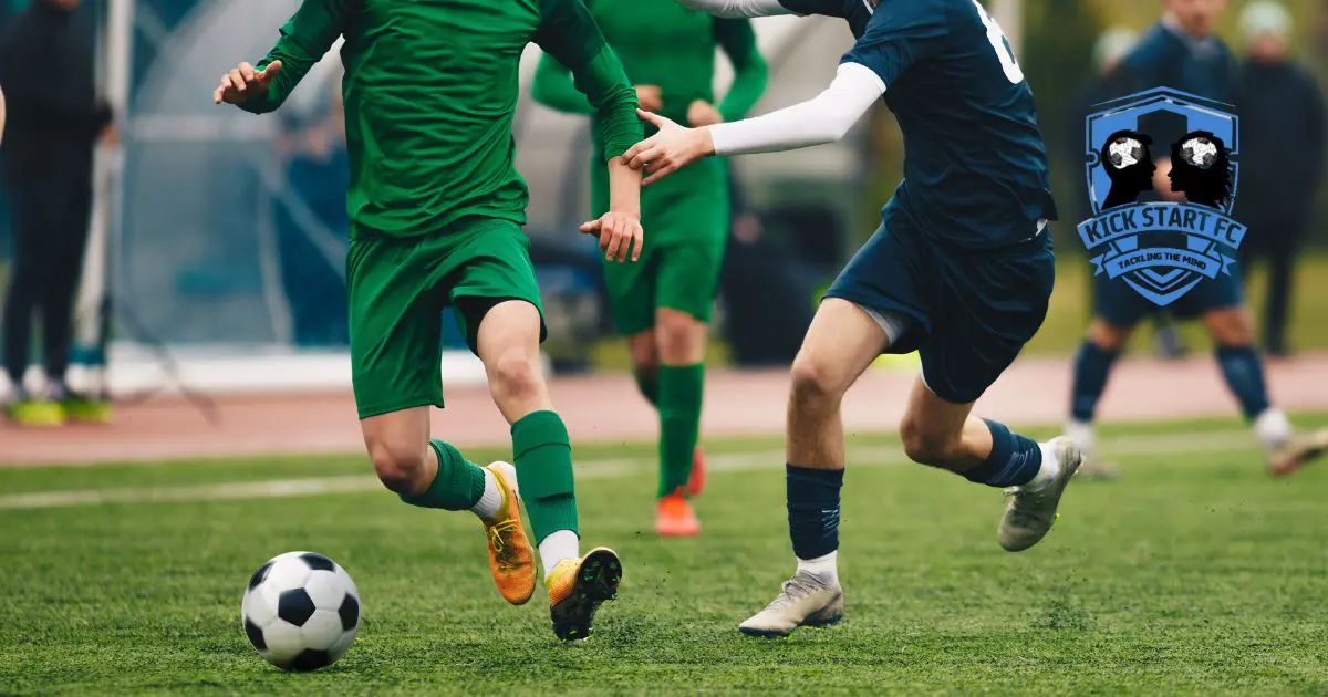 Football players in green and navy kits during a match, representing Kick Start FC, a Wiltshire charity using football therapy to support mental health and social connection.