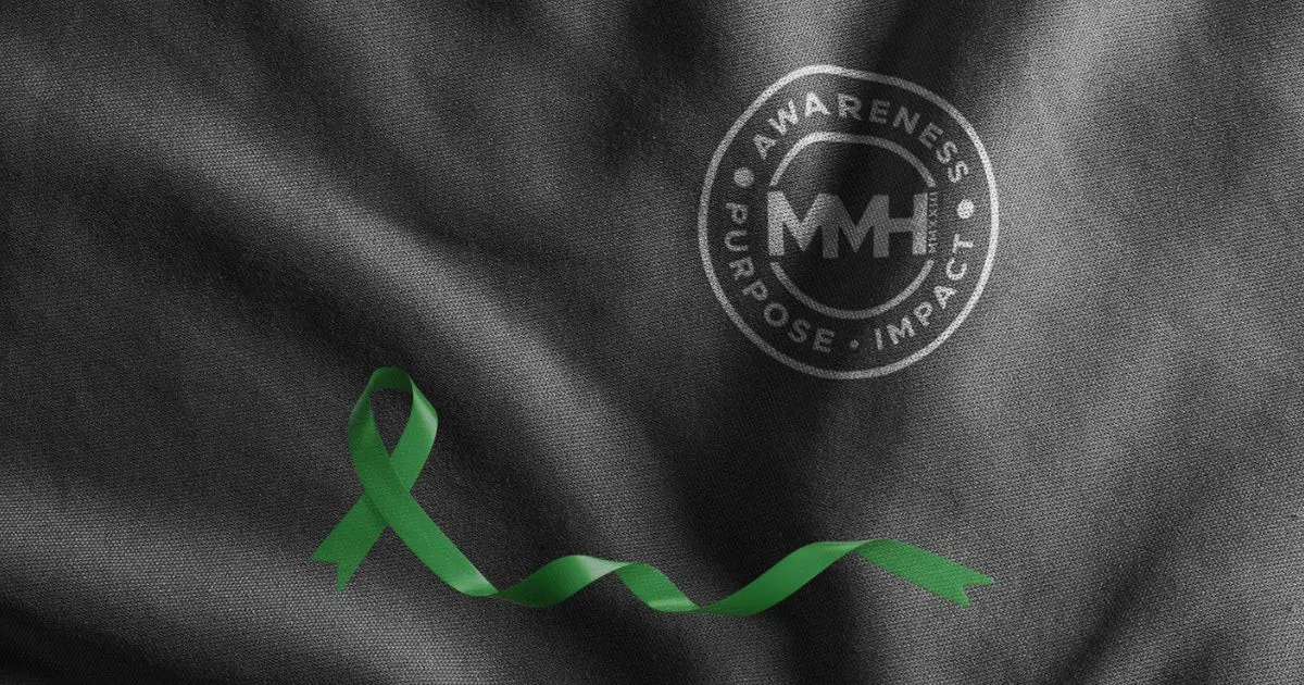 Green awareness ribbon on black textured background.