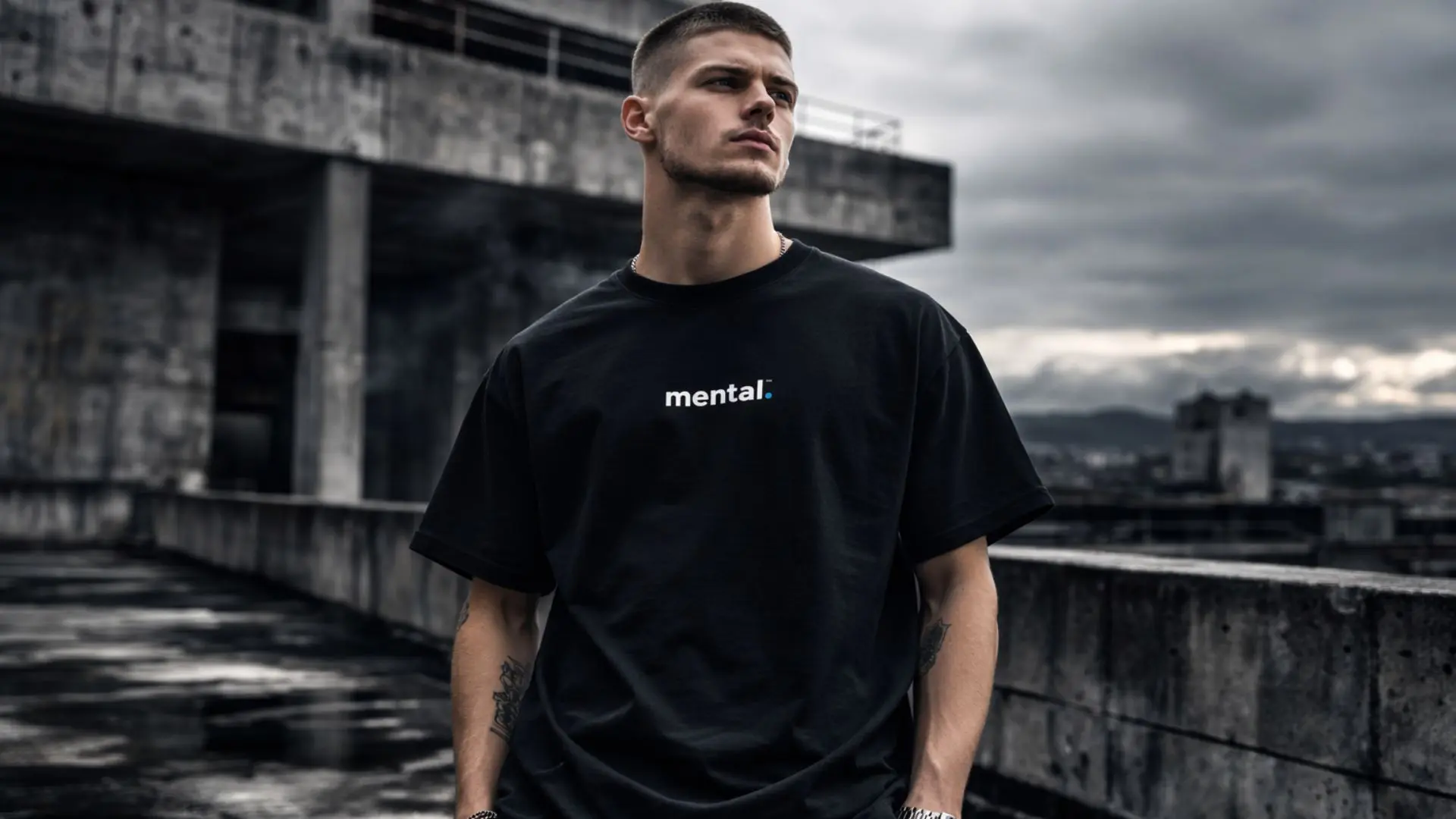 Man in black 'mental' shirt on urban rooftop.