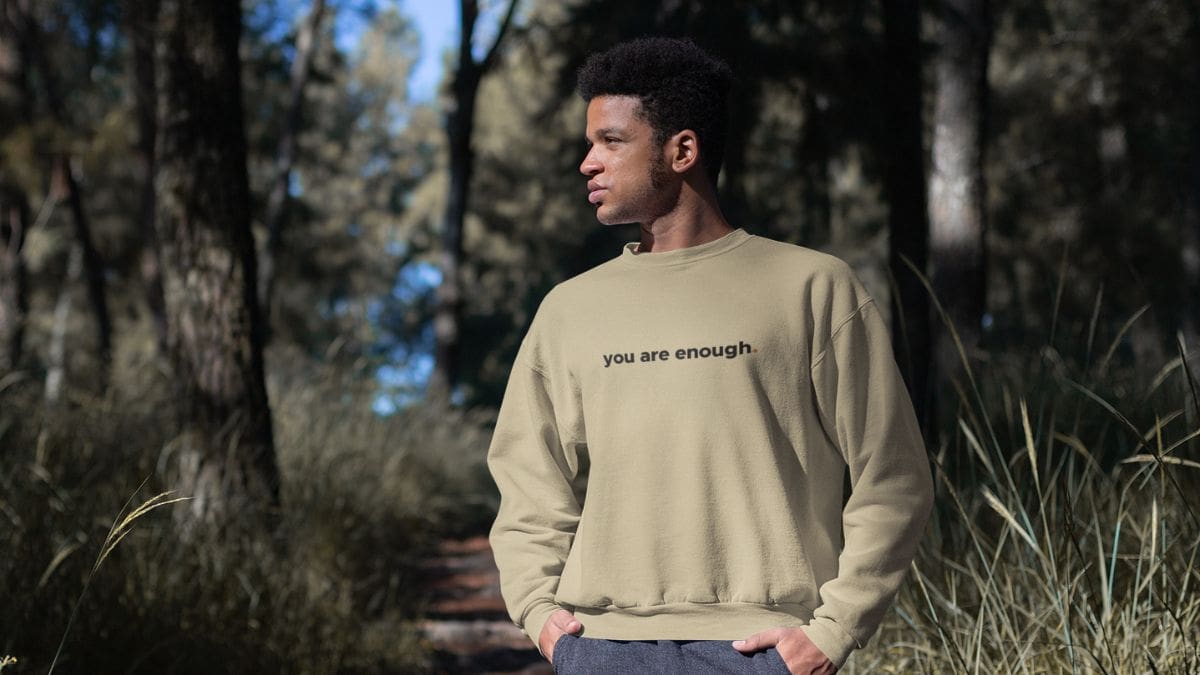 Man wearing sweatshirt in a forest.